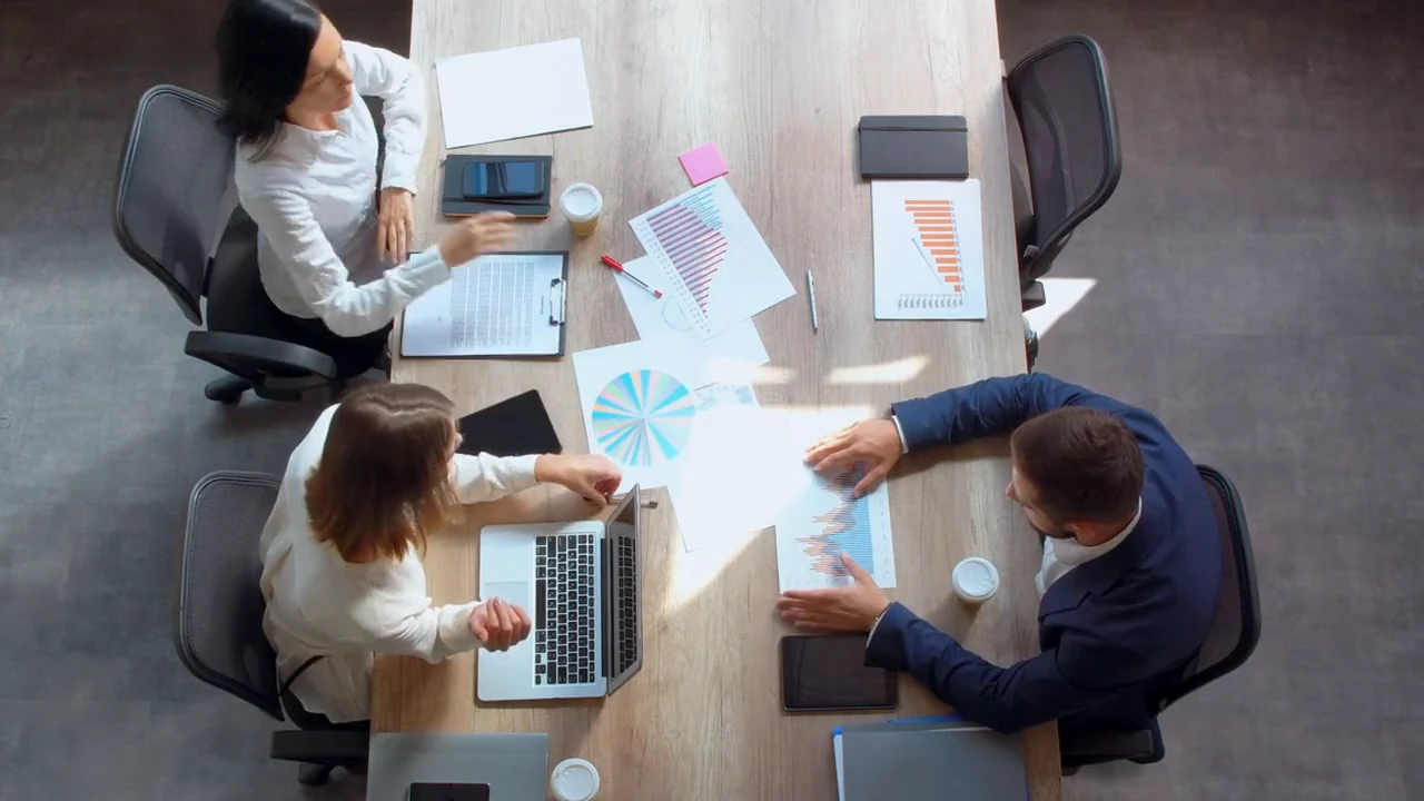 Illustrative business colleagues examining information and discussing assumptions