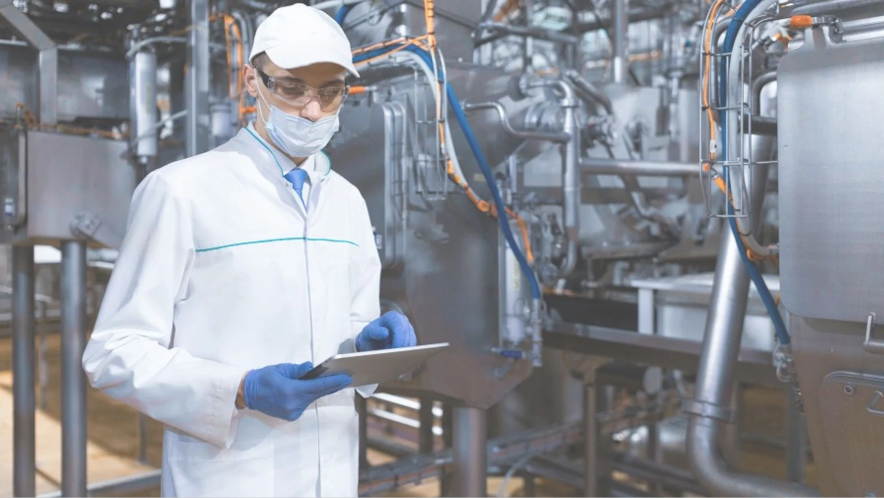 A laboratory or pilot-plant operator reviews equipment and recorded observations.