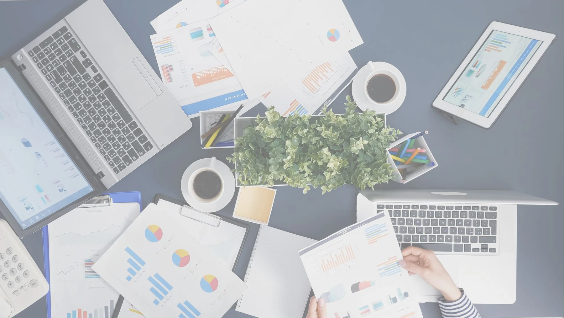 An overhead view of business planning documents and laptops.
